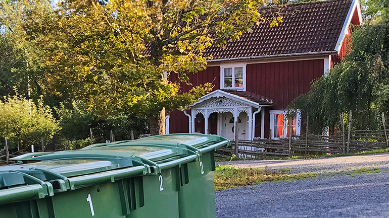 Tre FNI-kärl framför ett hus.