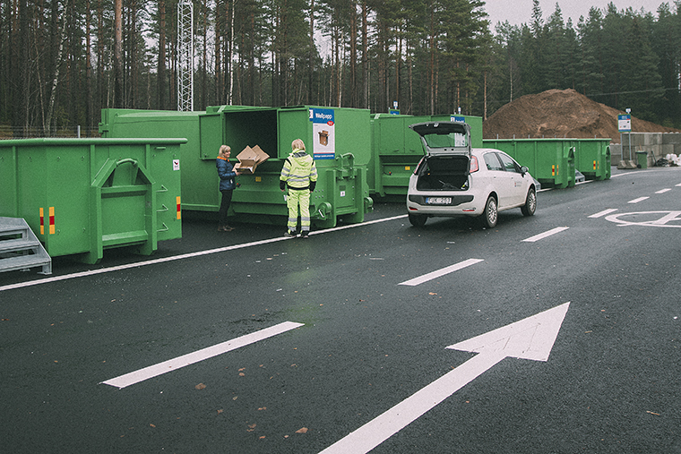 Två personer står framför en grön container på Bottnaryds sortergård